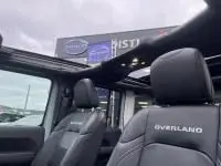 Intérieur du Jeep Wrangler Unlimited 2023 vert métal, vue côté gauche avec toit ouvrant et sièges Overland en cuir.