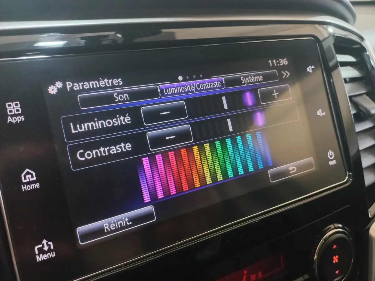 Écran tactile central du Mitsubishi L200 gris foncé, affichant les réglages de luminosité et contraste.
