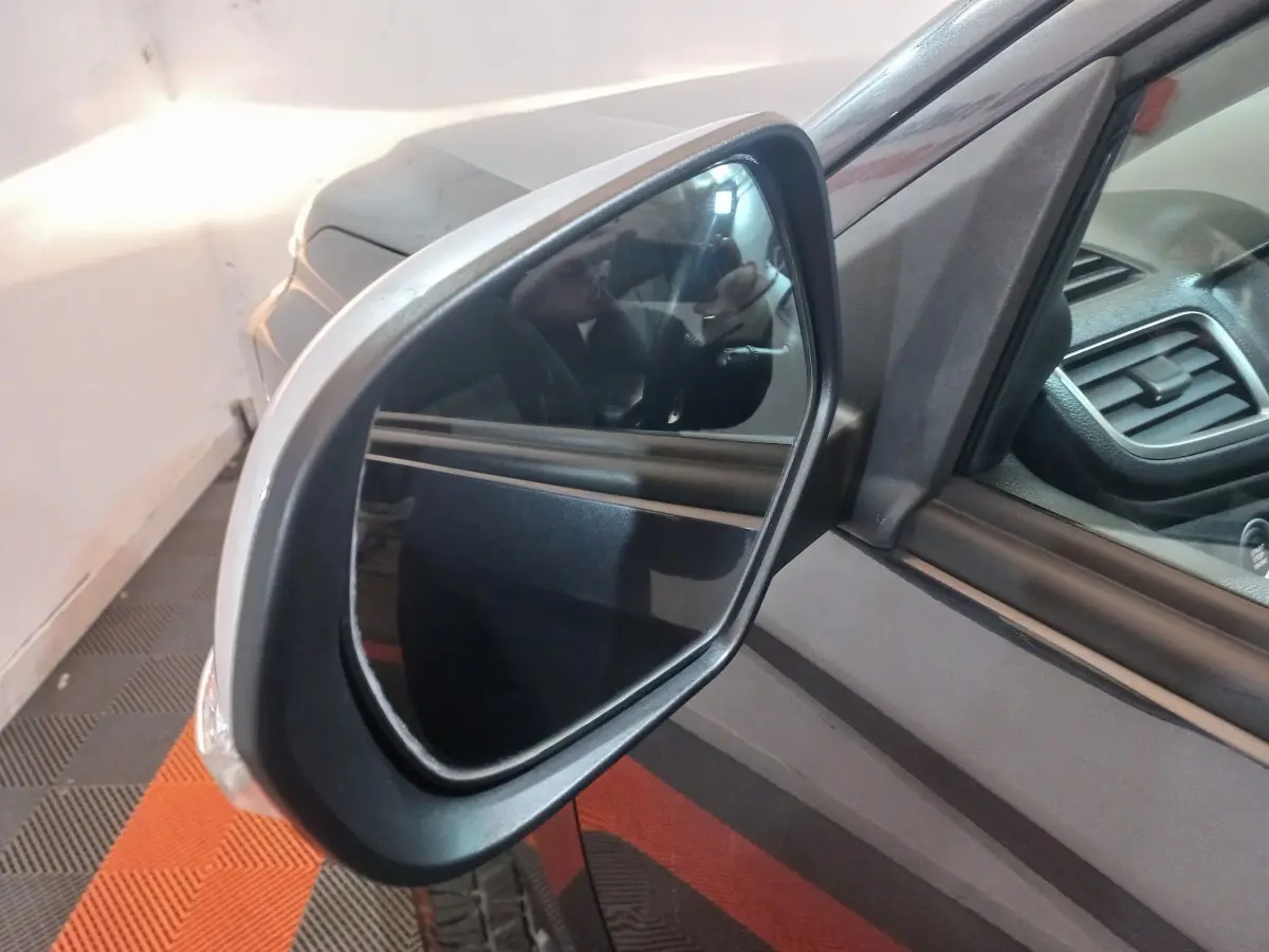 Rétroviseur côté gauche du Mitsubishi L200 gris foncé, vue rapprochée avec partie de l'habitacle visible.