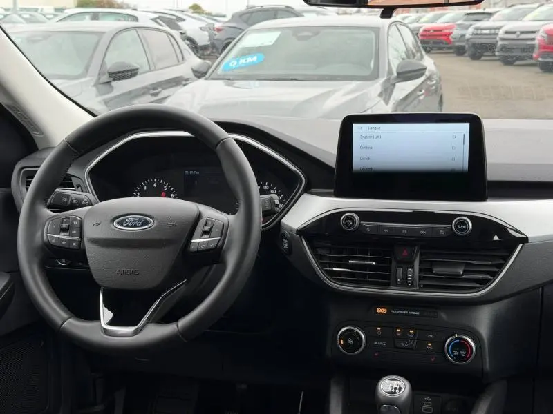 Vue intérieure du tableau de bord du Ford Kuga 2024, avec volant multifonction noir et écran tactile central.