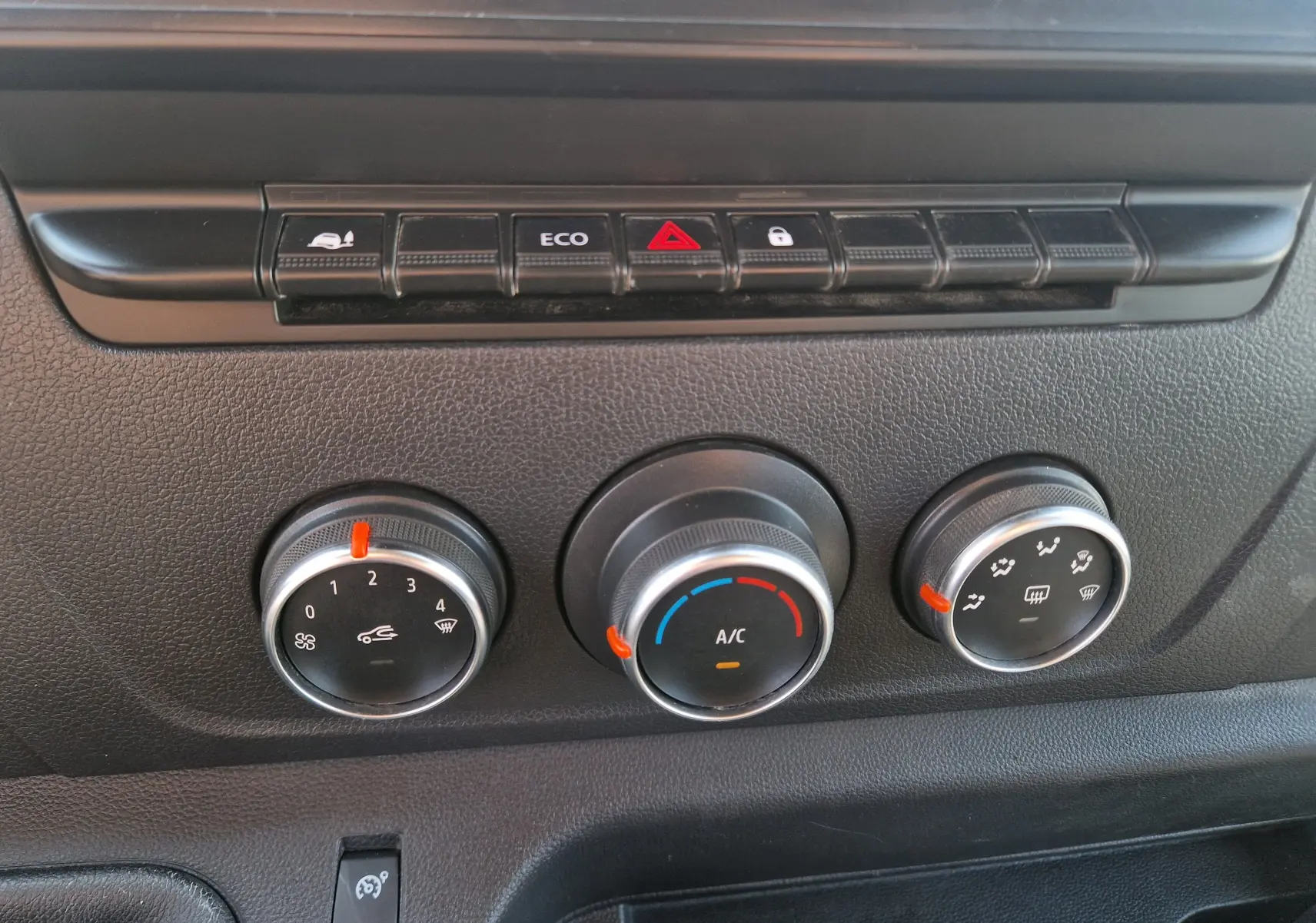 Gros plan sur les commandes de climatisation et boutons de fonction du tableau de bord du Renault Master blanc de 2022.
