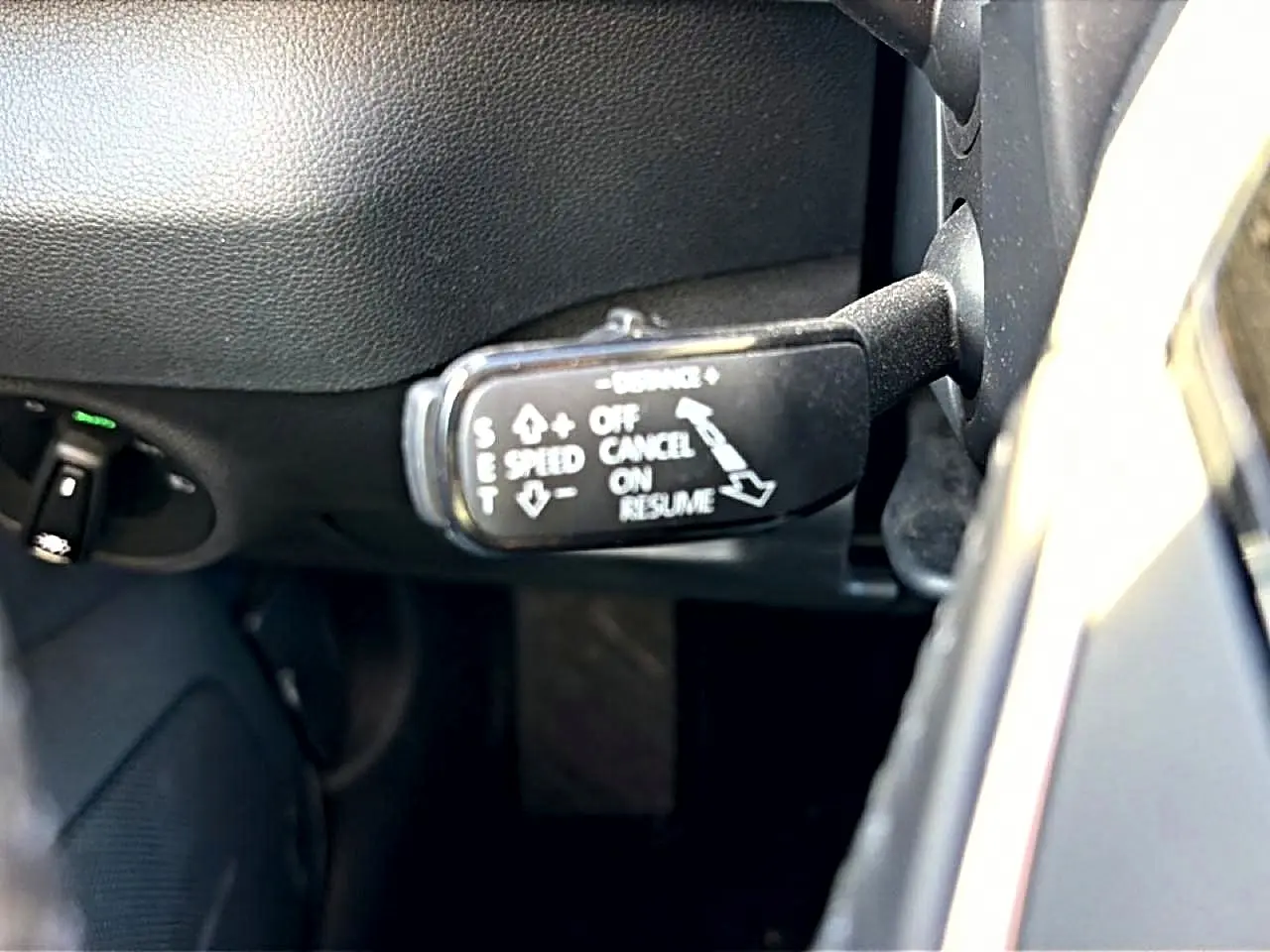 Gros plan sur le commodo de régulateur de vitesse dans l’habitacle noir d’un Skoda Karoq gris 2025.