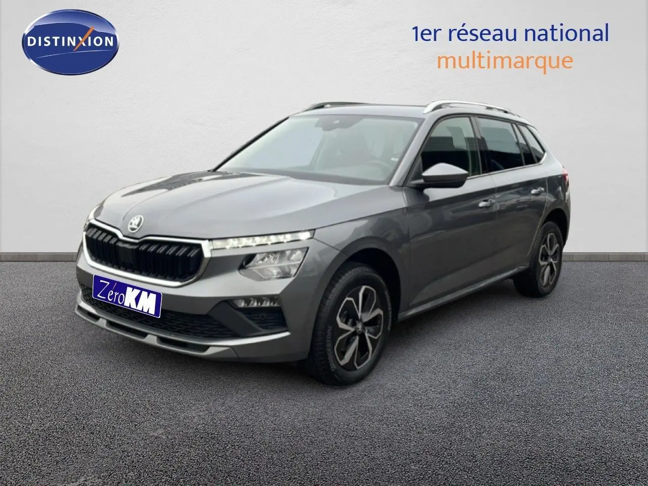Skoda Kamiq gris graphite métal vu en 3/4 avant droit avec jantes bi-ton et toit équipé de barres de toit.