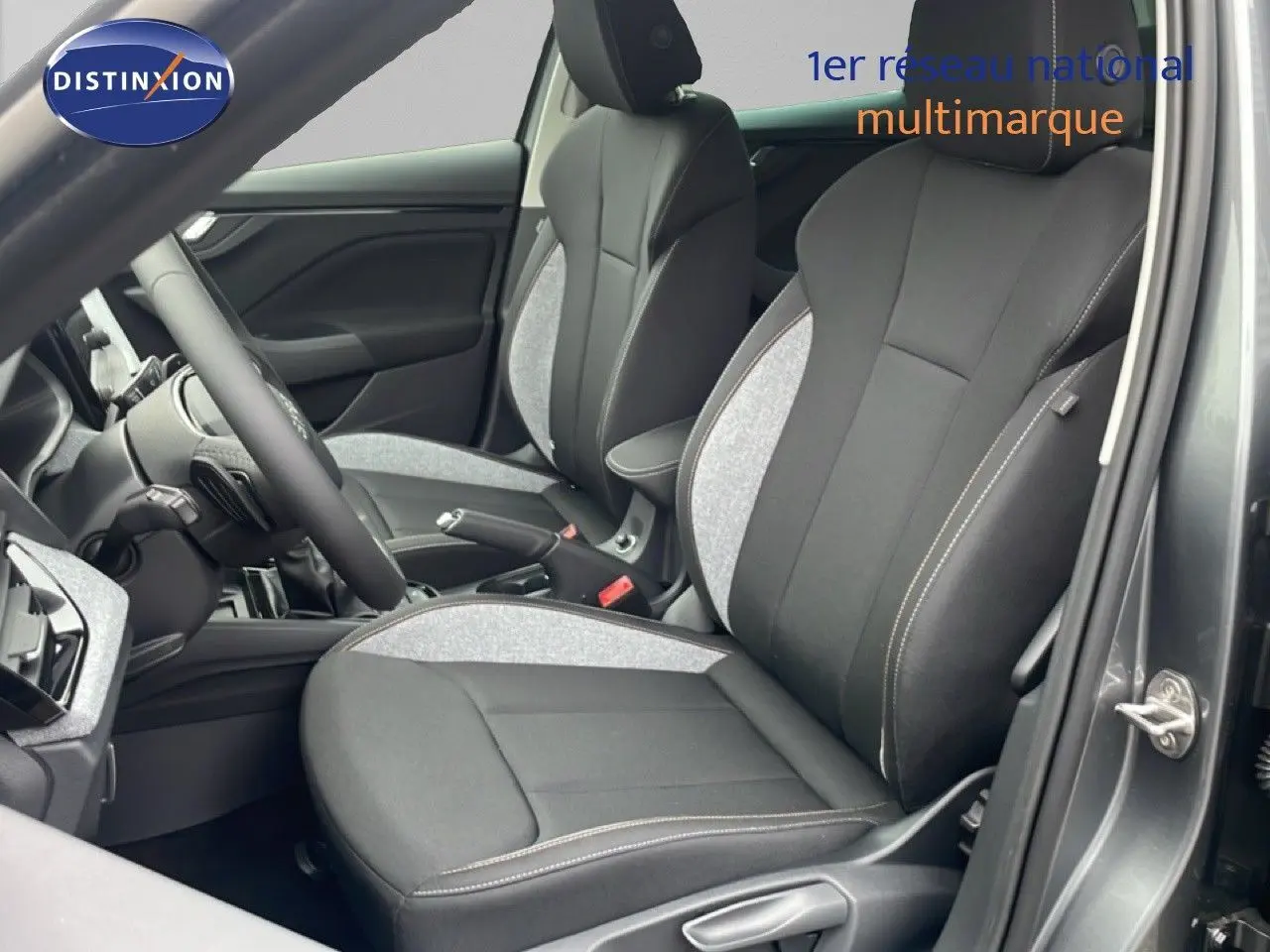 Vue intérieure côté conducteur du Skoda Kamiq gris graphite, sièges tissu noir et gris avec surpiqûres claires.