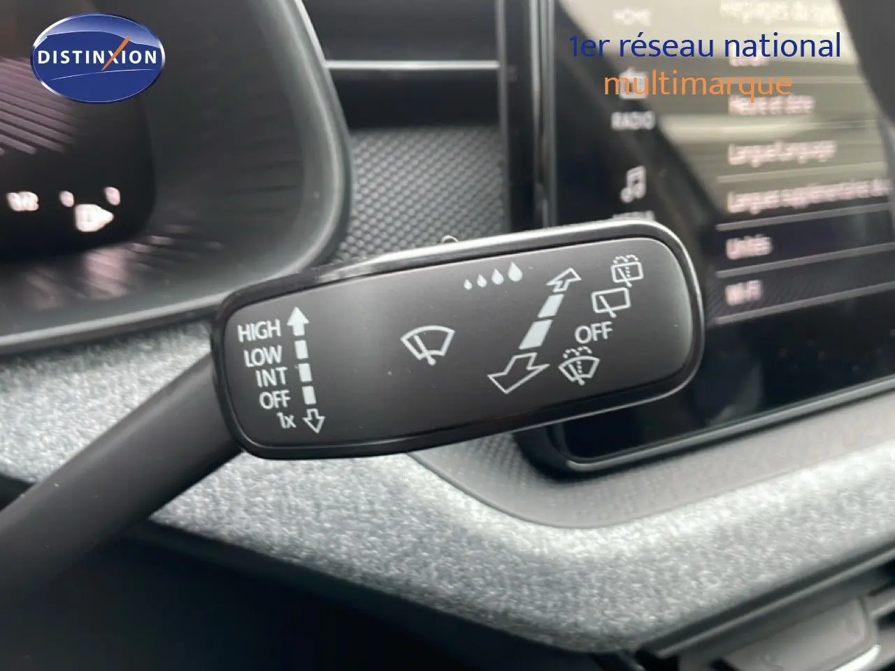 Gros plan sur la commande d'essuie-glace du Skoda Kamiq 2025 gris graphite, avec tableau de bord flou en arrière-plan.