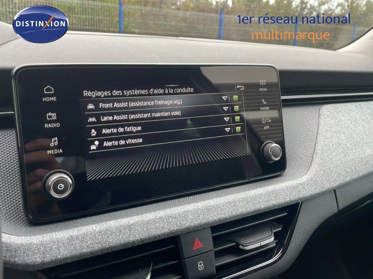 Écran central du tableau de bord du Skoda Kamiq 2025 montrant les réglages d'aides à la conduite, ambiance intérieure grise.