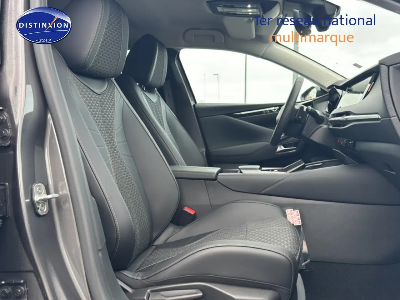 Vue intérieure côté conducteur du DS4 2024 gris platinium, mettant en valeur les sièges en cuir noir et la console centrale moderne.