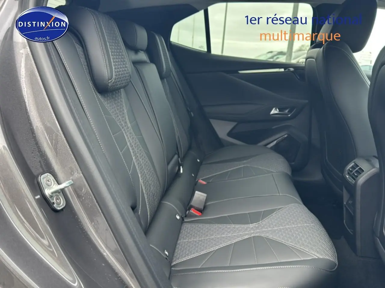 Vue intérieure côté gauche des sièges arrière en cuir gris du DS4 Hybride 145 Pallas 2024 avec accoudoirs et finitions soignées.