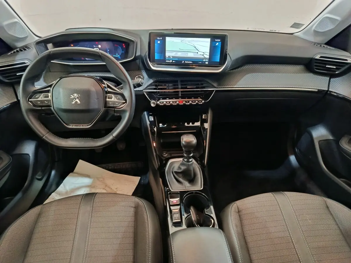Intérieur de la Peugeot 208 blanc, vue de face sur le tableau de bord avec écran tactile 10 pouces et volant cuir.