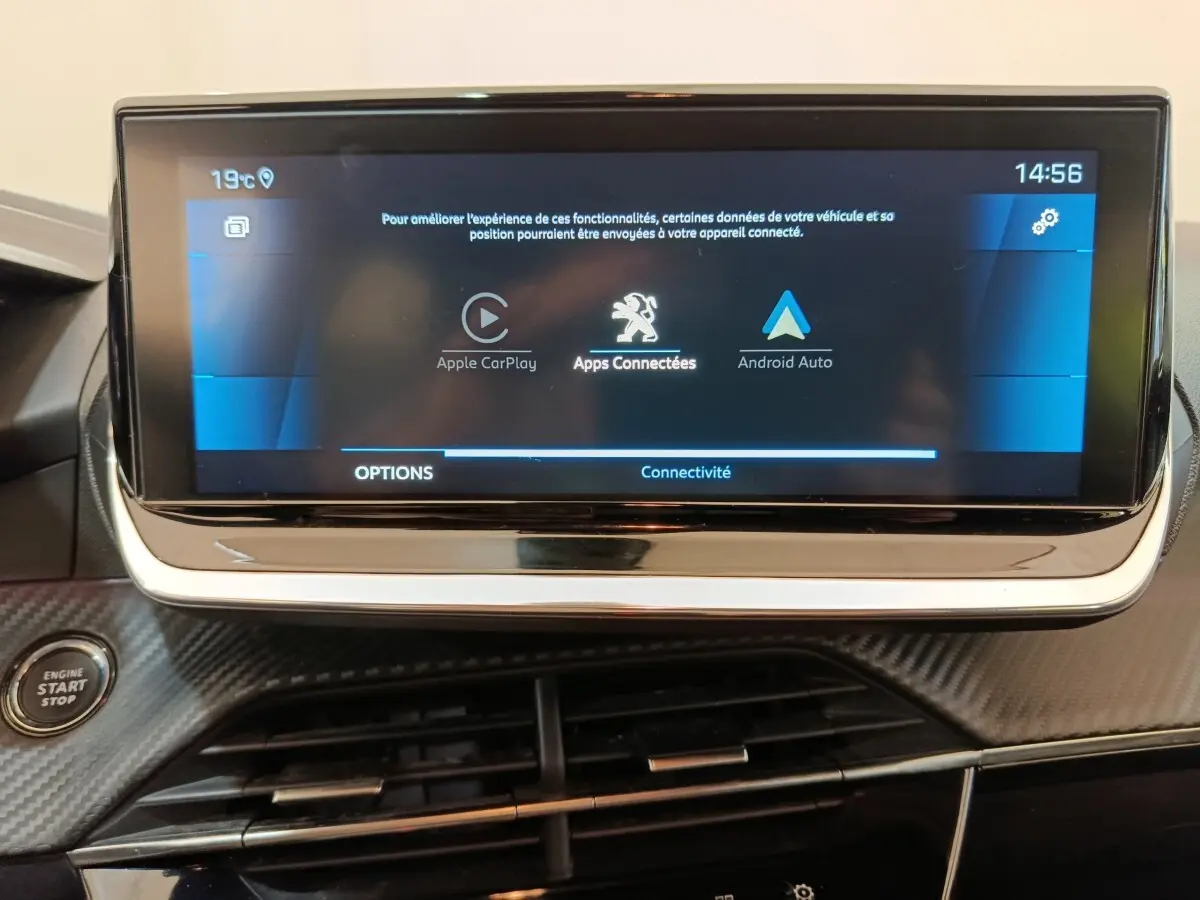 Écran tactile central de la Peugeot 208 blanc, affichant Apple CarPlay et Android Auto, avec bouton démarrage visible.