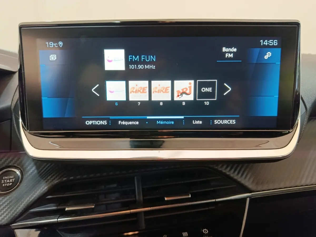 Écran tactile central de 10 pouces affichant les stations radio dans l'habitacle d'une Peugeot 208 blanche.