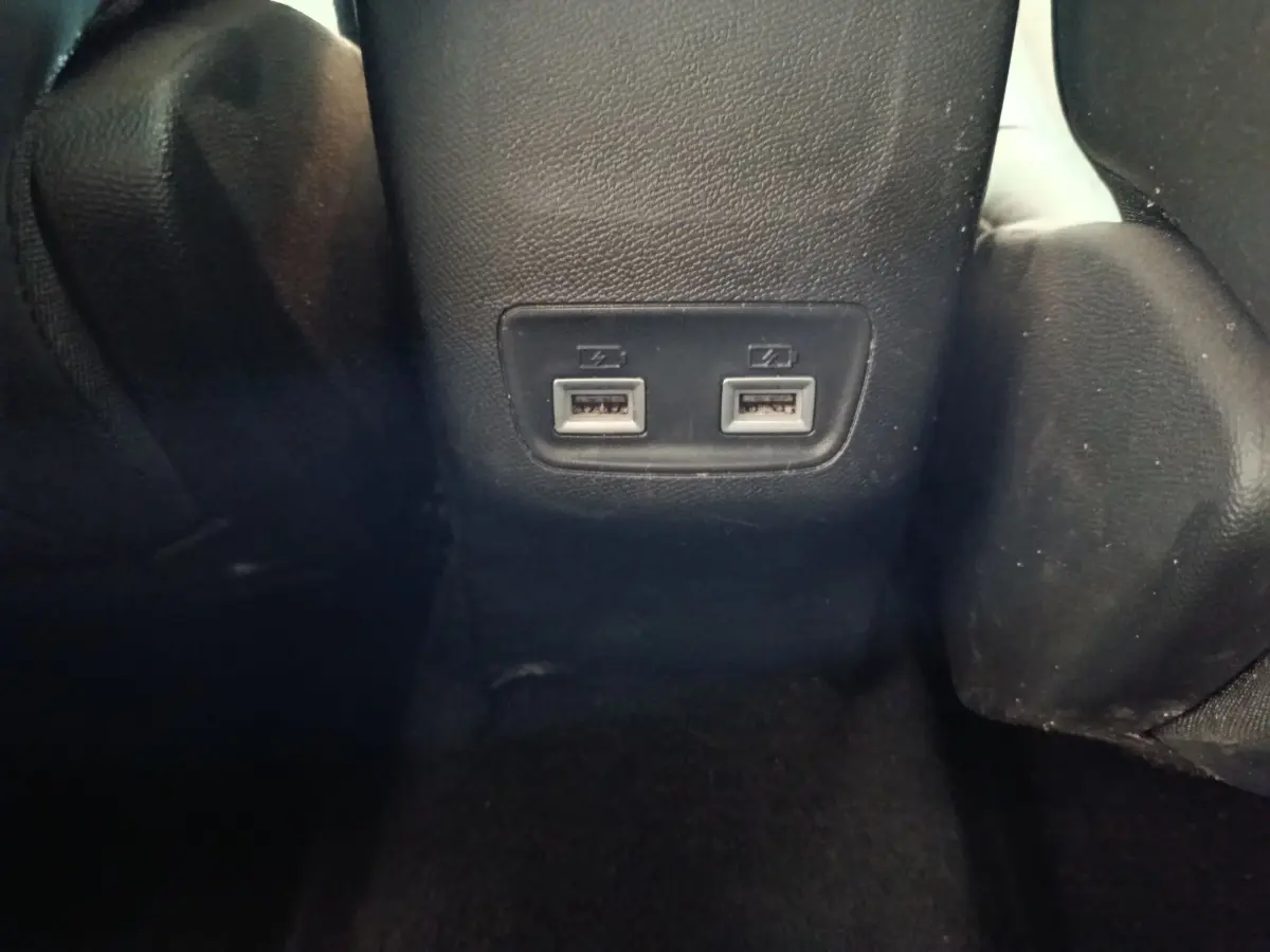 Prise double USB arrière sur console centrale noire dans l’habitacle d’une Peugeot 208 blanche 2021.