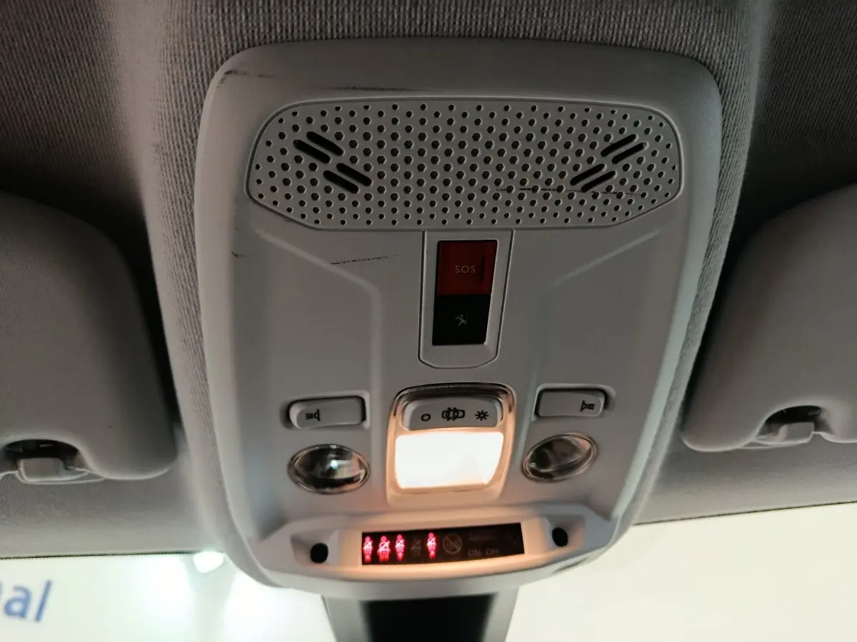 Vue en gros plan du plafonnier intérieur blanc avec commandes d'éclairage et bouton SOS du Peugeot 208 blanc.