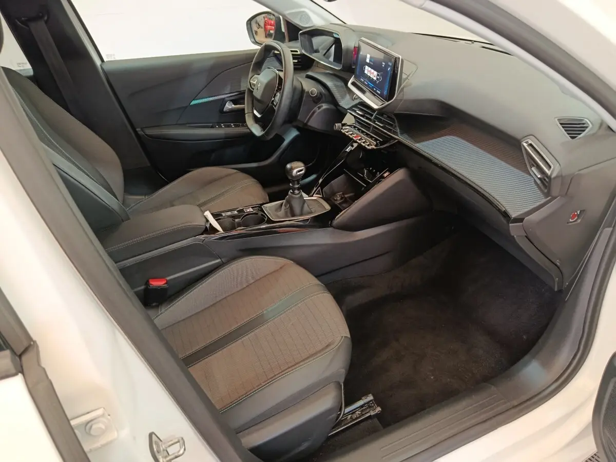 Intérieur de la Peugeot 208 blanc, vue côté conducteur, tableau de bord moderne avec écran tactile 10 pouces.