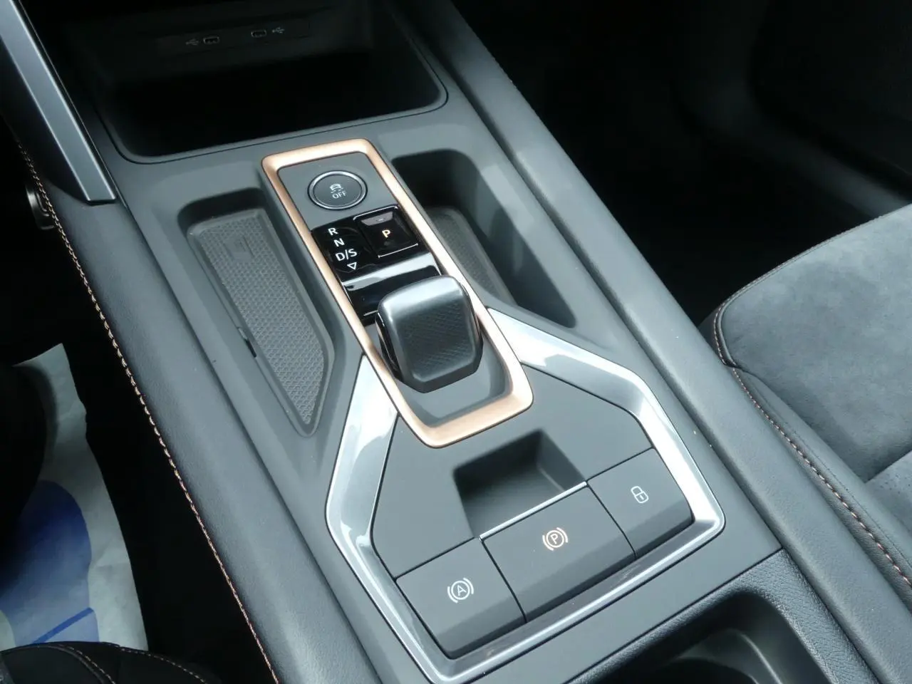 Gros plan sur la console centrale avec levier de vitesses et finitions cuivrées du CUPRA Formentor gris magnétique.