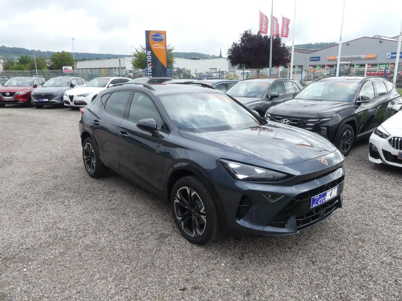 CUPRA Formentor gris magnétique en 3/4 avant droit, avec jantes alliage et signature lumineuse Tri-LED visible.
