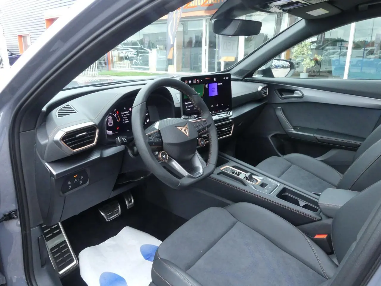 Intérieur avant droit de la CUPRA Formentor gris magnétique, avec volant Supersports et sièges suédine noirs.