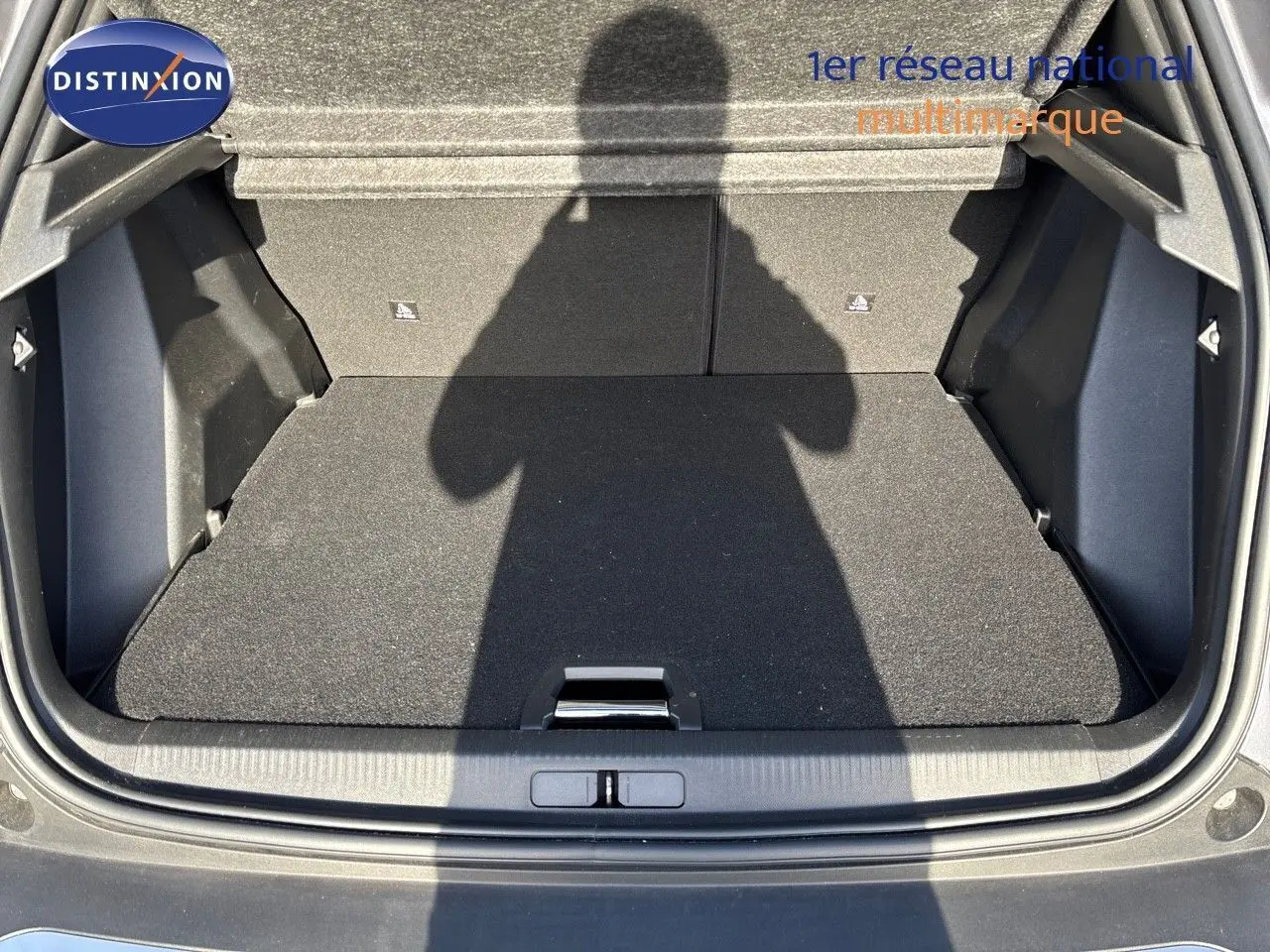 Coffre ouvert vu de l'arrière d'un Peugeot 2008 gris Artense, montrant un espace de chargement propre et spacieux.