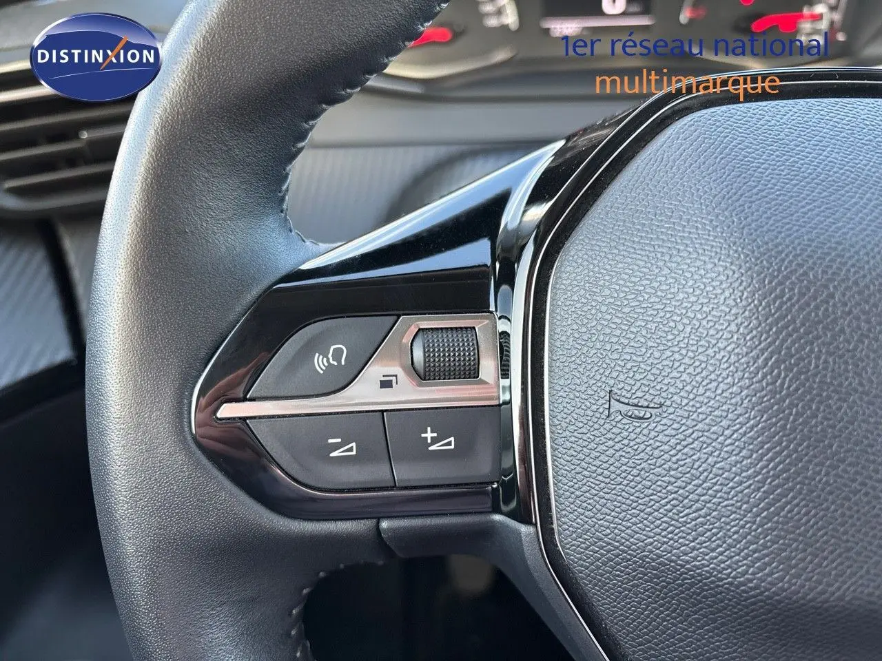 Gros plan sur les commandes gauche du volant en cuir noir du Peugeot 2008 gris Artense, version 1.2 PureTech 130 Active 2021.