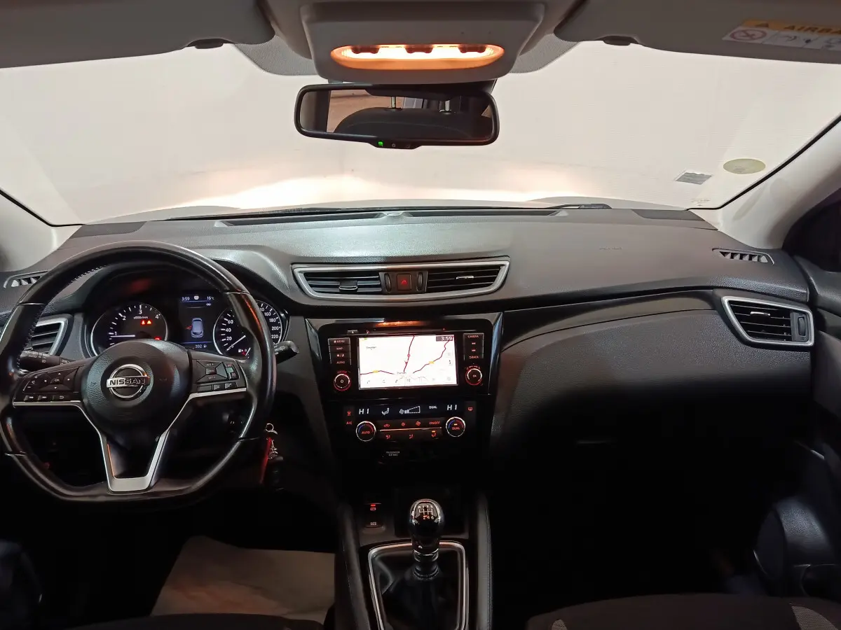 Vue intérieure avant du Nissan Qashqai 1.5 DCI 115 Business Edition 2019, tableau de bord avec écran tactile et volant cuir multifonctions.