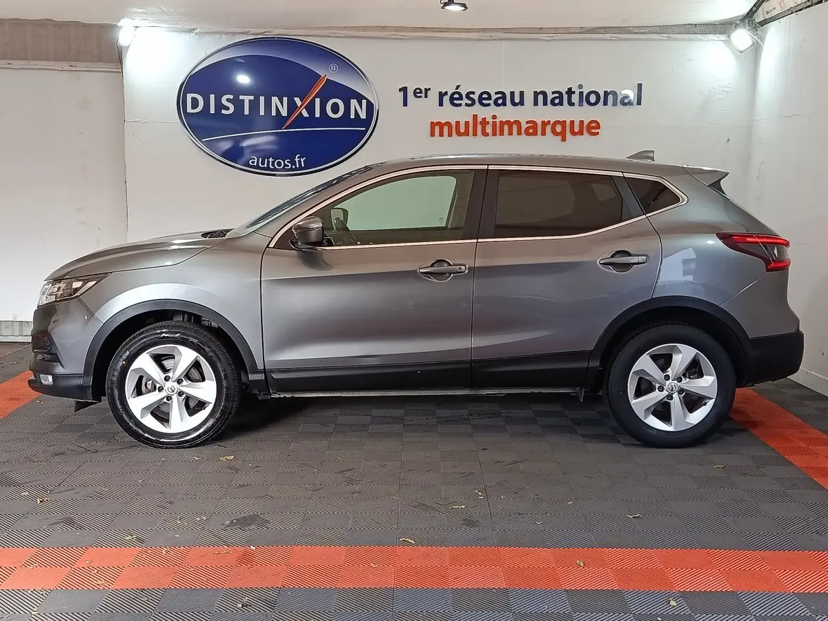 Vue latérale droite d'un Nissan Qashqai gris clair 2019 garé en intérieur avec jantes alliage et vitres teintées.