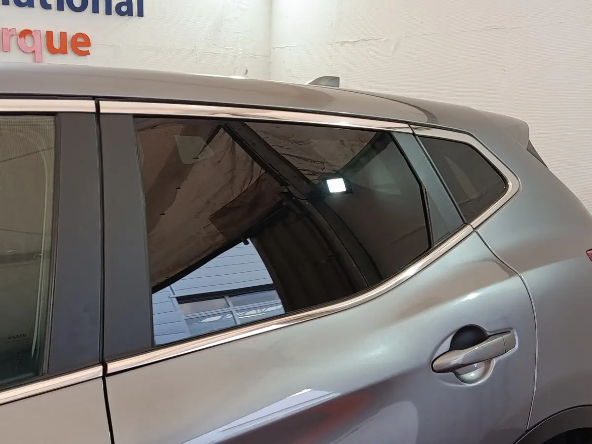 Vue latérale droite sur la porte arrière gris clair du Nissan Qashqai 1.5 DCI 115 Business Edition avec poignée intégrée.