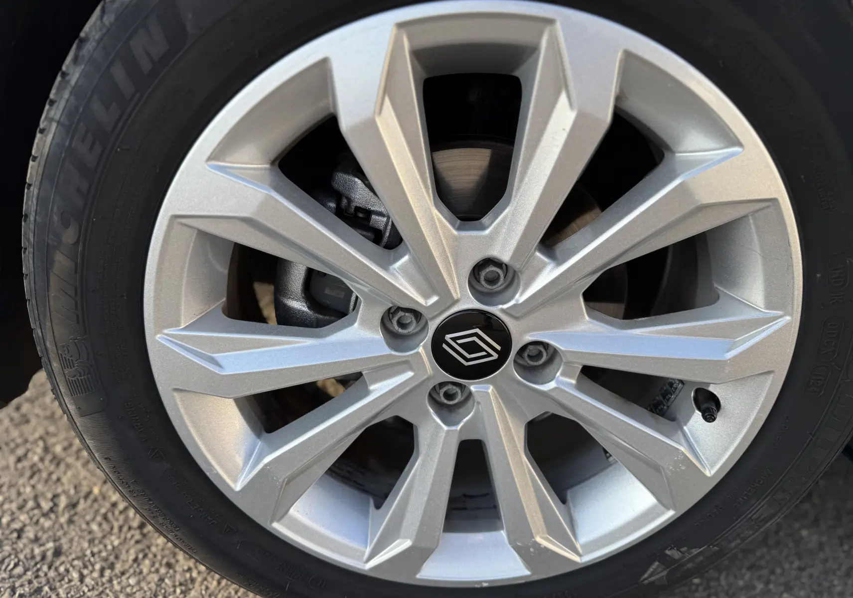 Gros plan sur la jante alliage argentée de la Renault Clio V 2025, soulignant le logo central distinctif.