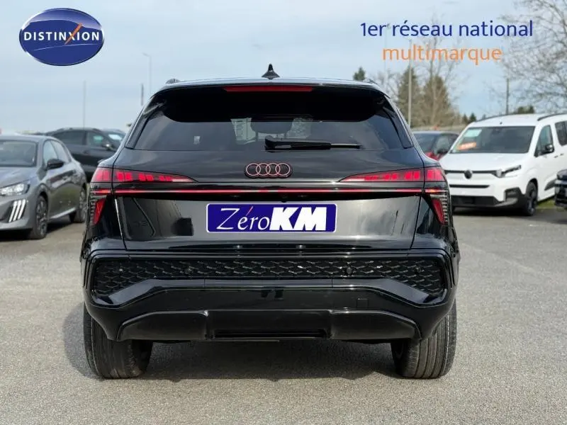 Vue arrière d'un Audi Q3 2026 noir mythique métallisé, avec feux LED reliés par une bande lumineuse rouge distinctive.