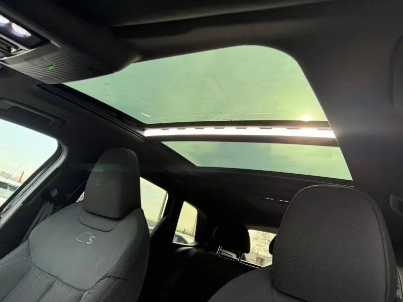 Vue intérieure de l'Audi Q3 2026 avec toit panoramique et sièges S line en tissu noir.
