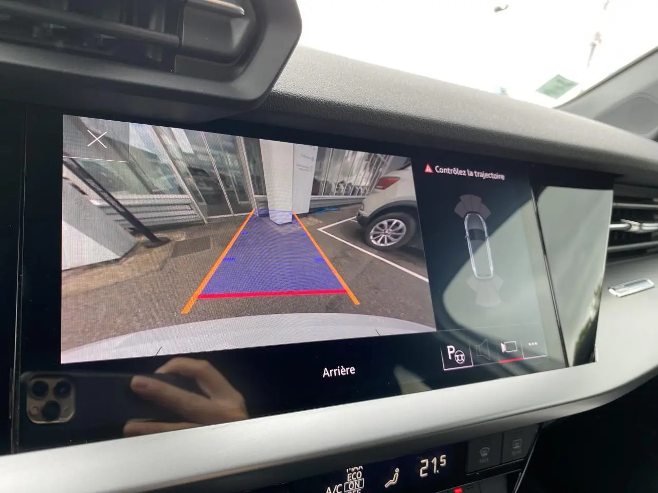 Vue de l'écran de caméra de recul de l'Audi A3 Sportback blanche, montrant l'arrière et les lignes de guidage du stationnement.