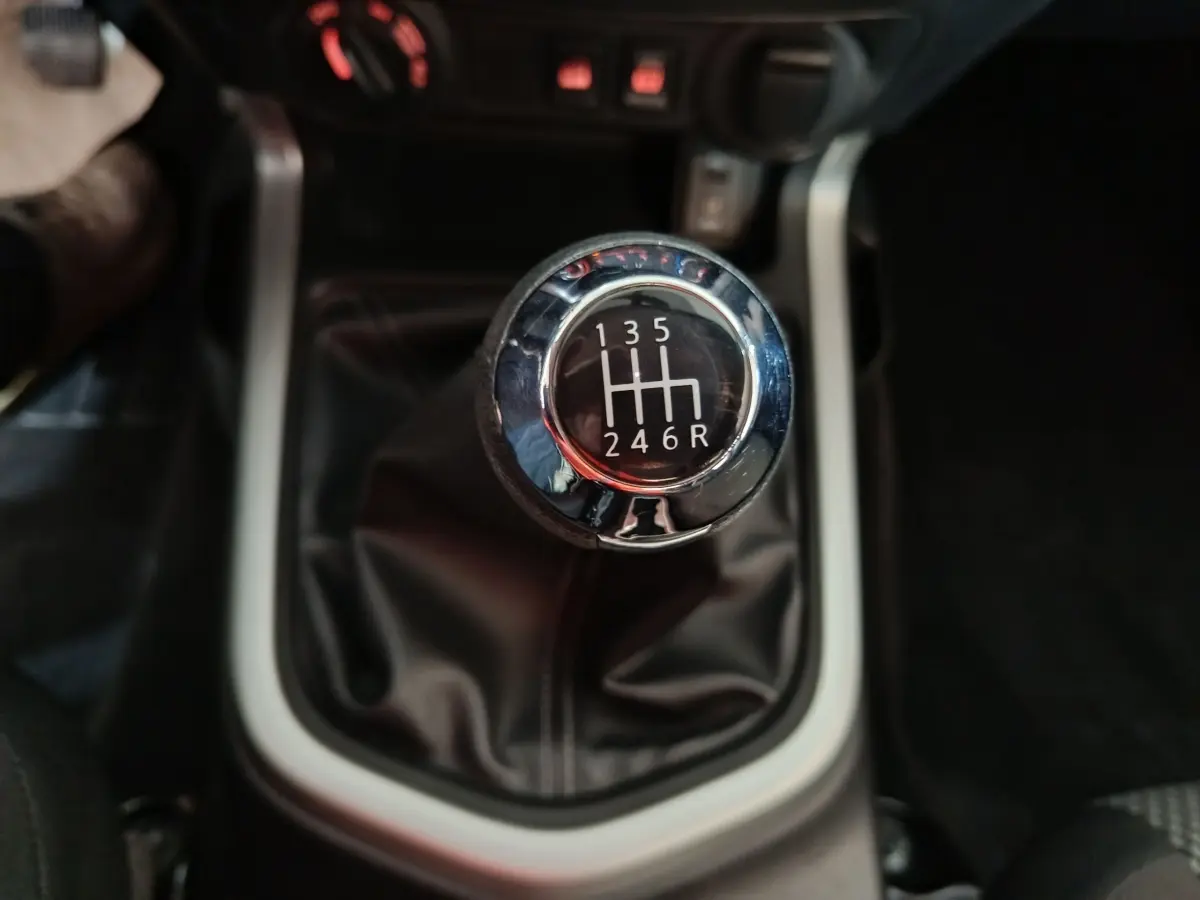 Gros plan sur le levier de vitesses manuel noir et chrome du Nissan Navara Double-Cab gris clair de 2018.