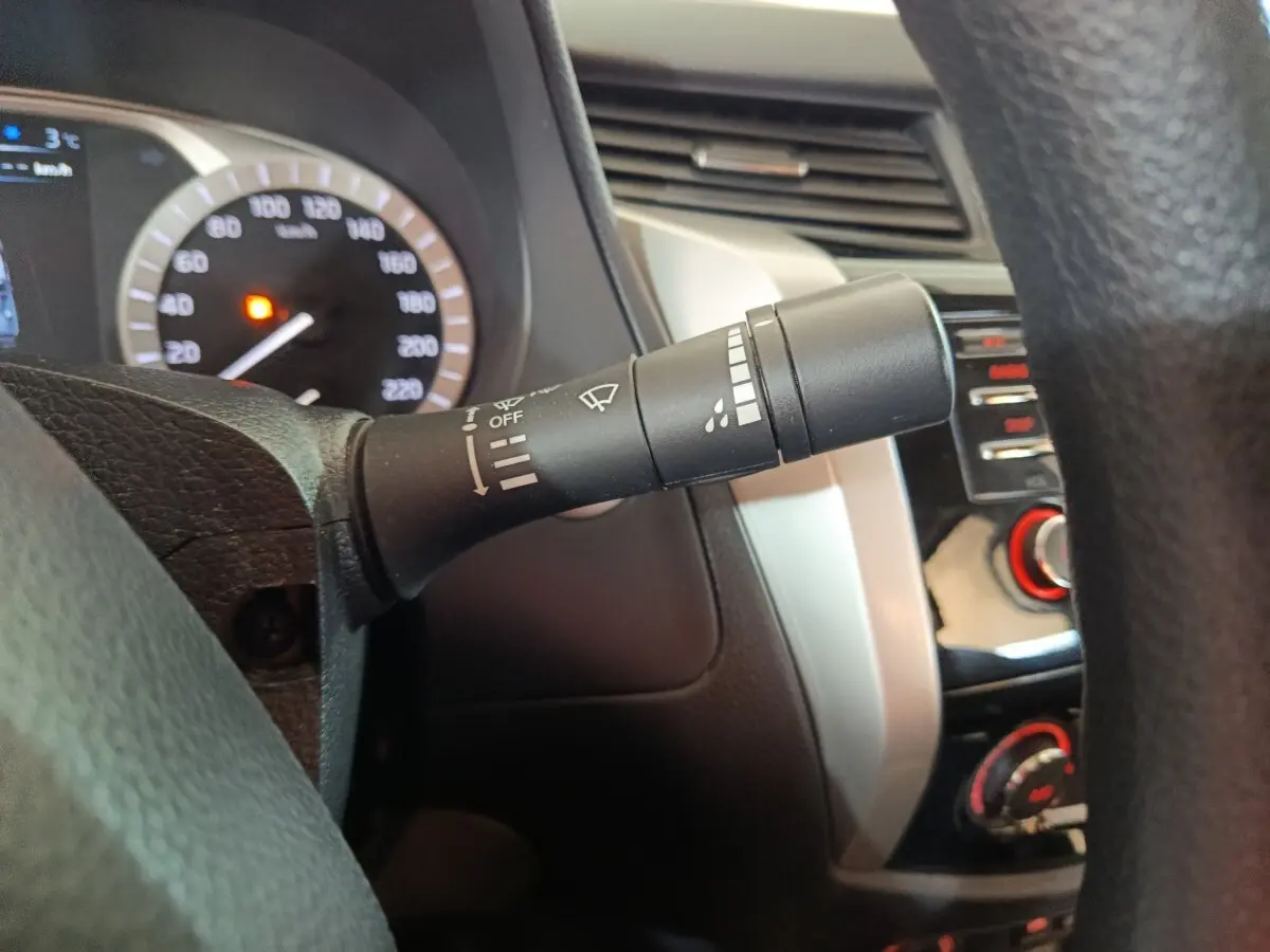 Gros plan sur la commande d’essuie-glace côté droit du tableau de bord gris clair du Nissan Navara 2018.