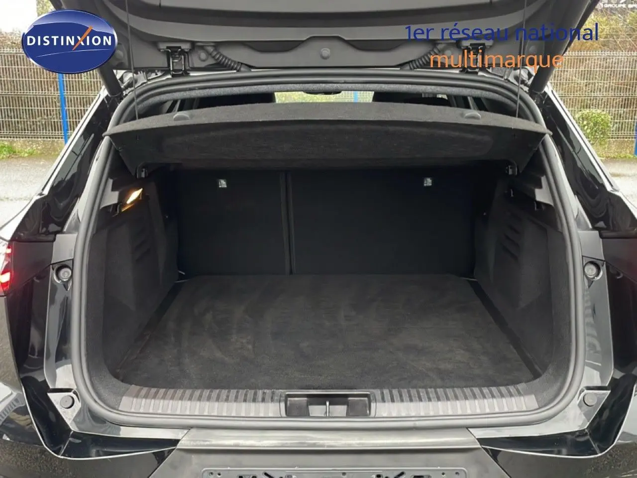 Coffre ouvert vu de l'arrière d'une Renault Symbioz noire étoile métal, montrant un espace de chargement vide et propre.