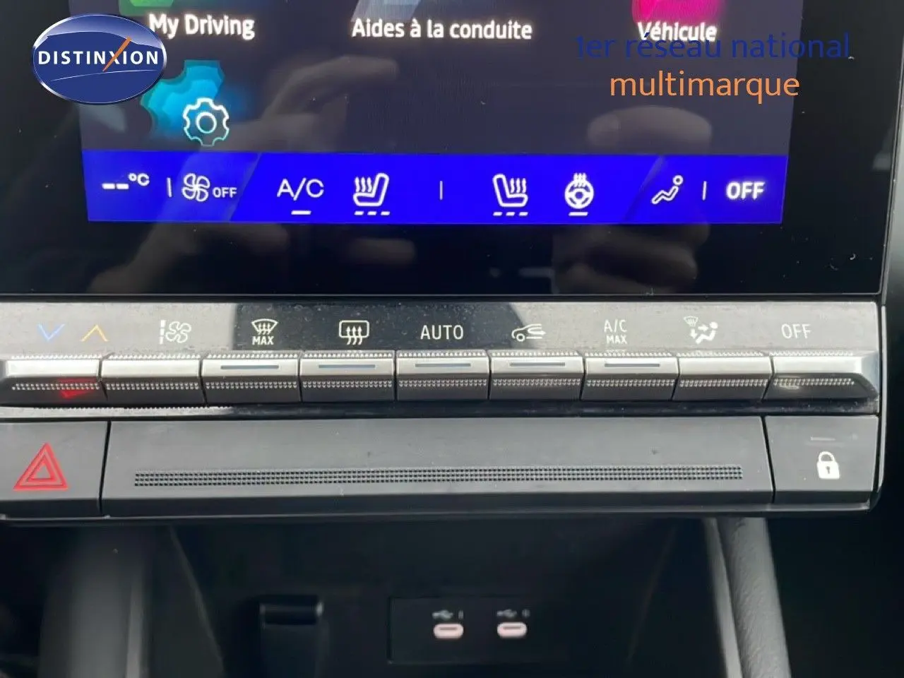 Gros plan sur la console centrale du Renault Symbioz 2025 noir étoile métal, affichage des commandes climatisation et boutons fonctionnels.