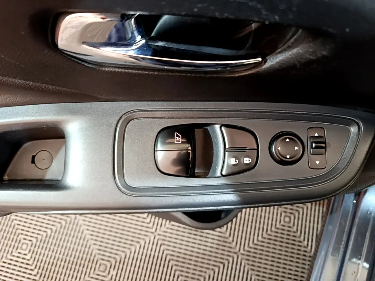 Vue rapprochée du panneau de commandes des vitres et rétroviseurs côté conducteur d’une Nissan Micra gris foncé 2020.
