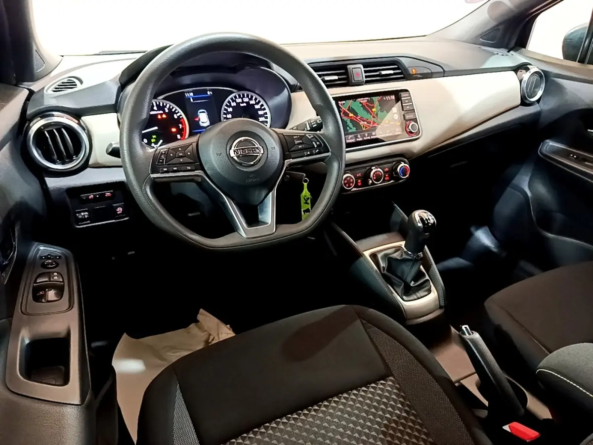 Vue intérieure avant droite du tableau de bord gris clair et noir d’une Nissan Micra IG-T 100 Business Edition avec volant multifonctions et écran tactile.