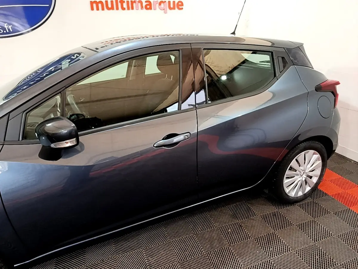 Profil côté gauche d'une Nissan Micra IG-T 100 Business Edition gris foncé, avec rétroviseur électrique et poignées chromées.