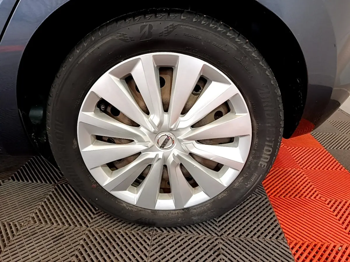 Gros plan sur la roue avant droite d'une Nissan Micra gris foncé, avec jante en alliage et pneu Bridgestone.