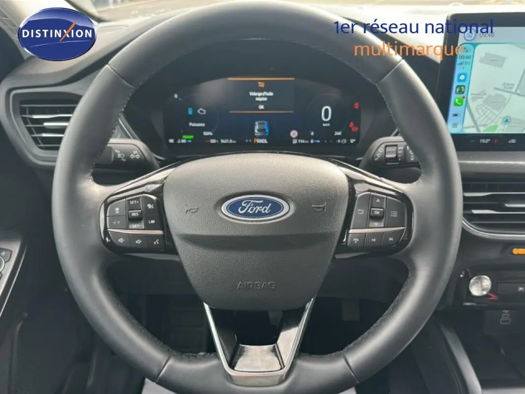 Vue rapprochée du volant noir de la Ford Kuga 2025 avec tableau de bord numérique et écran tactile latéral.