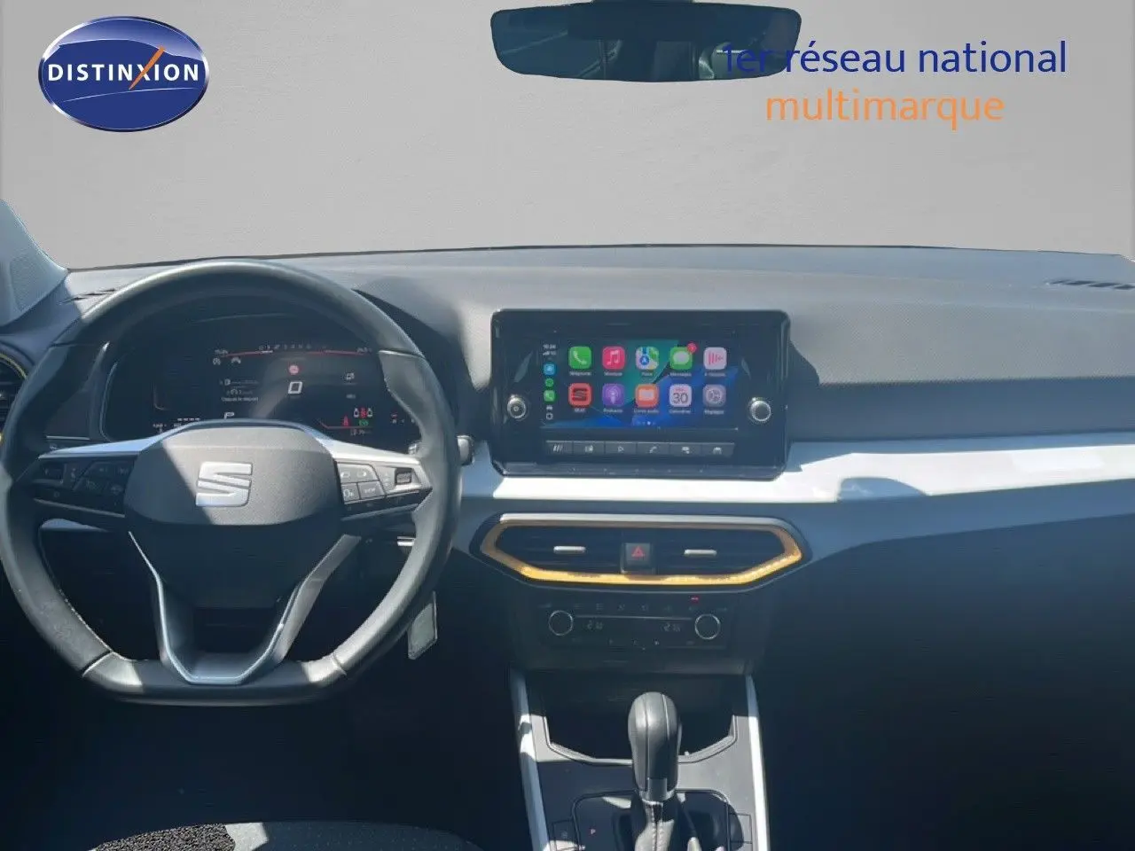Vue intérieure frontale du tableau de bord du SEAT Arona 2025, avec écran tactile central et volant multifonction noir.