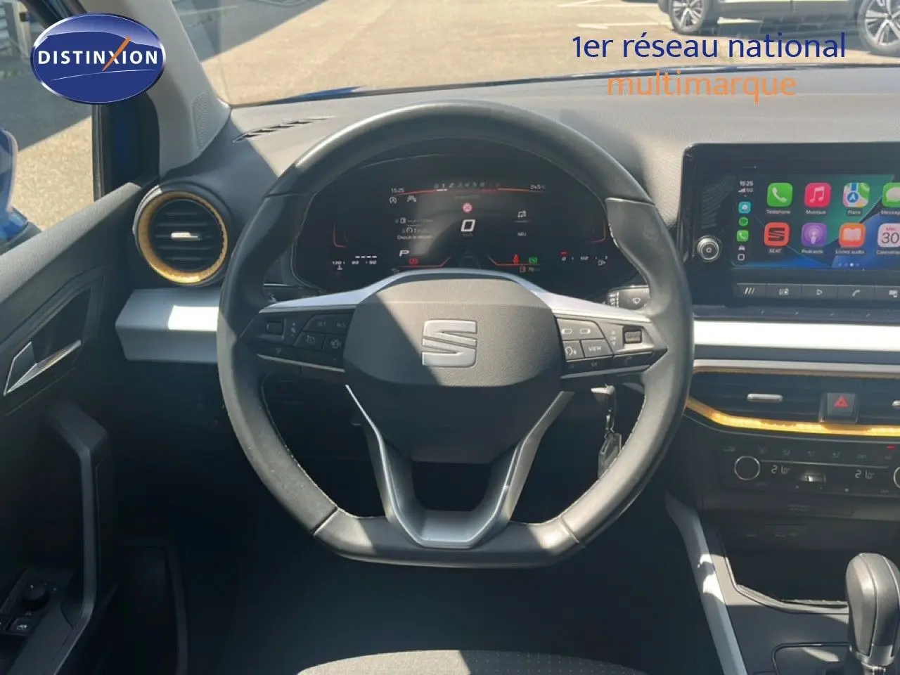 Vue intérieure centrée sur le volant du SEAT Arona 2025, tableau de bord numérique et écran tactile visibles.