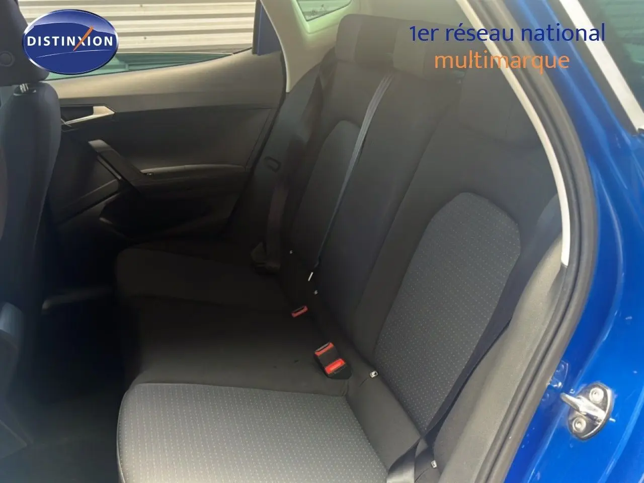 Vue intérieure côté droit montrant la banquette arrière noire du SEAT Arona bleu saphir 2025 avec porte ouverte.