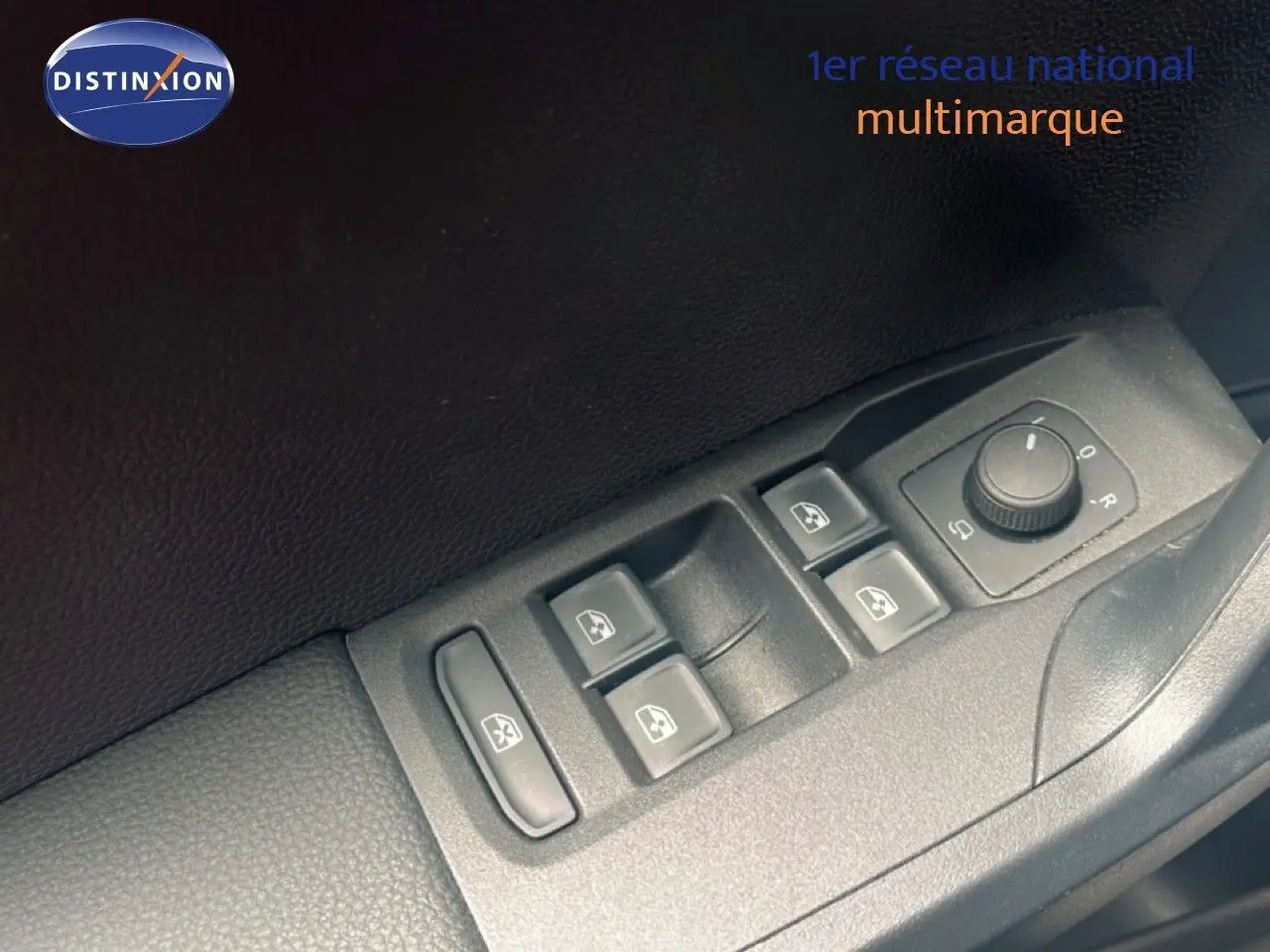 Gros plan sur les commandes des vitres électriques et réglage des rétroviseurs côté conducteur du SEAT Arona bleu saphir 2025.