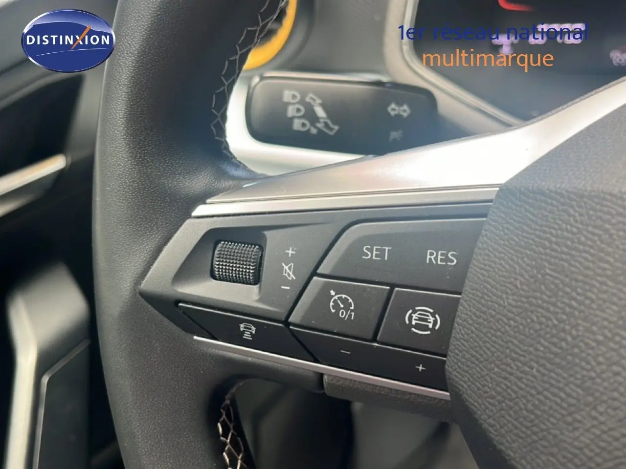 Gros plan sur les commandes au volant du SEAT Arona 2025, volant cuir noir avec boutons multifonctions.