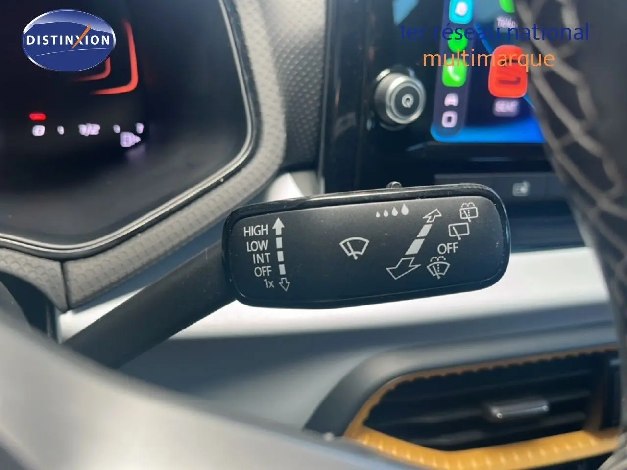 Gros plan sur la commande d’essuie-glace du SEAT Arona 2025, intérieur noir avec écran tactile en arrière-plan.