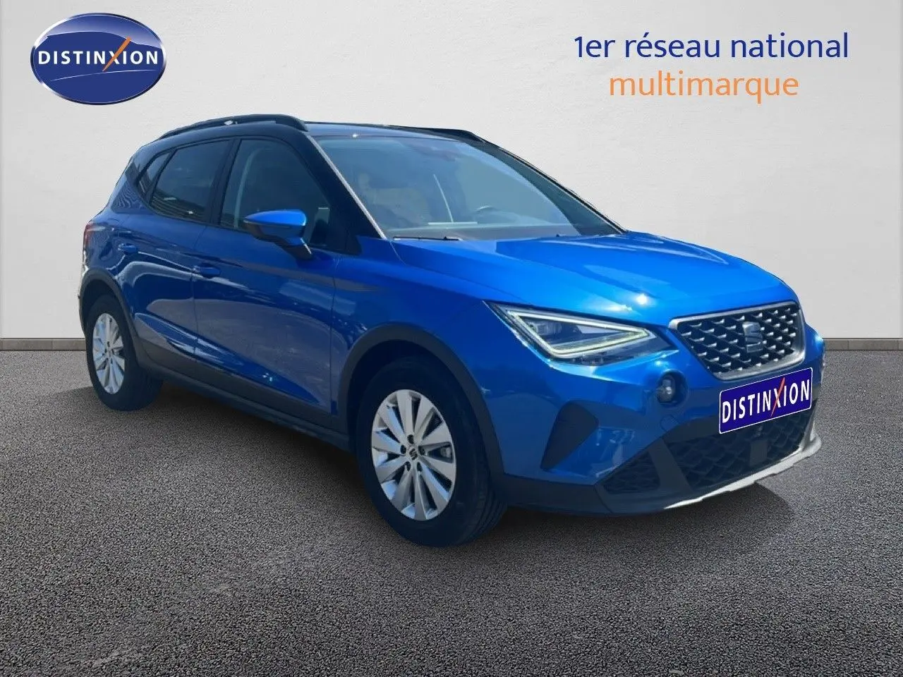 SEAT Arona bleu saphir métal avec toit noir, vue 3/4 avant droit mettant en valeur ses optiques LED et sa calandre.