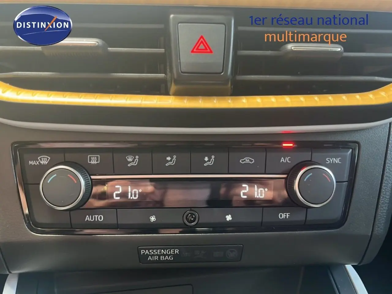 Gros plan sur la console centrale du SEAT Arona 2025, avec climatisation digitale et bandeau décoratif jaune.