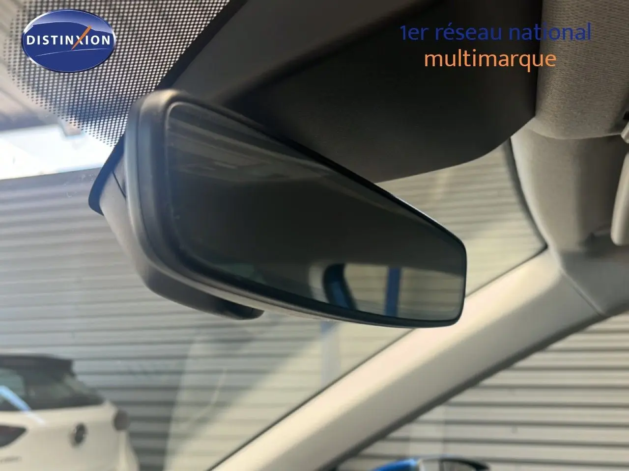 Rétroviseur intérieur en gros plan d'un SEAT Arona 2025 bleu saphir métal avec toit noir, vue depuis l'habitacle avant.