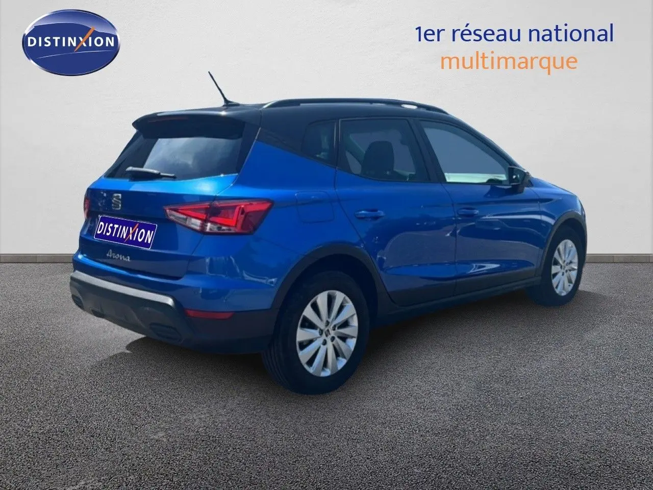 Vue 3/4 arrière droite d'un SEAT Arona bleu saphir avec toit noir, sur fond neutre en extérieur.