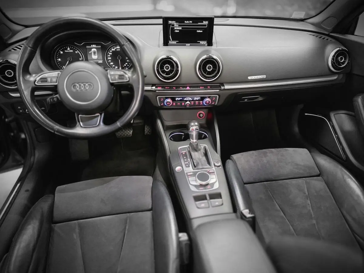 Intérieur de l'Audi A3 Cabriolet 2015, vue frontale du tableau de bord et console centrale avec volant cuir et écran MMI.